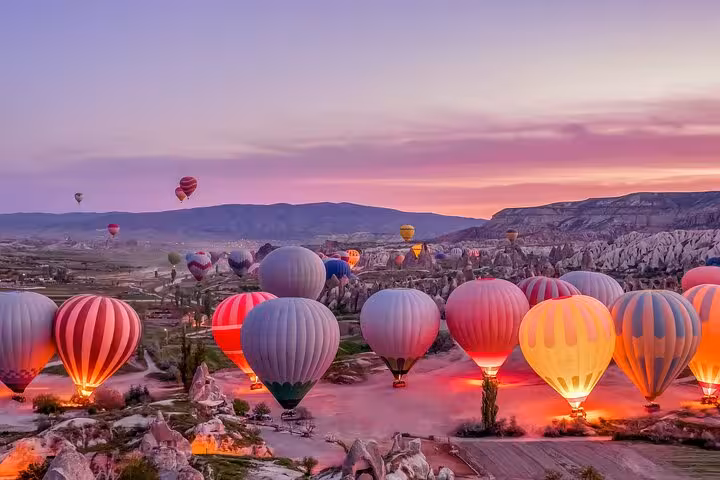 Hot air balloon launch at dawn over Cappadocia valleys, 1-day guided sightseeing tour with vehicle service