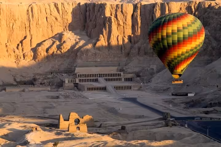 Hot air balloon flying above Hatshepsut Temple in Luxor on private overnight tour from Hurghada, West Bank views