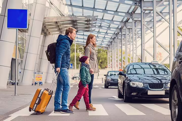 Family with luggage crossing to taxi for Hurghada Airport private transfer, fast meet-and-greet arrival service