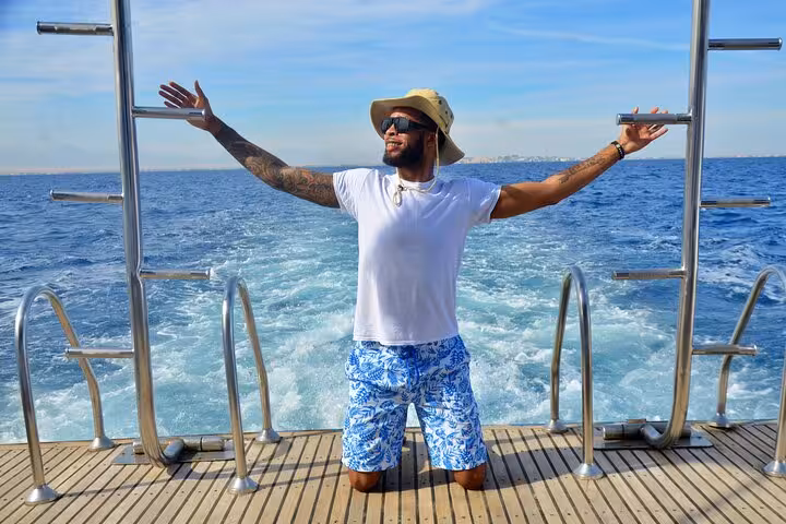 Guest relaxing on Hurghada boat deck during Orange Bay and Giftun Island snorkel trip in Red Sea