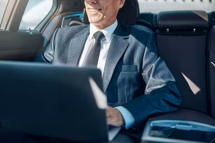 Business traveler relaxing in a private car, Hurghada to Cairo one-way hotel transfer with Wi‑Fi comfort