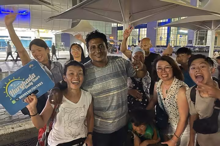 Happy travelers with guide at Hurghada airport for private full-day Cairo tour by domestic flight