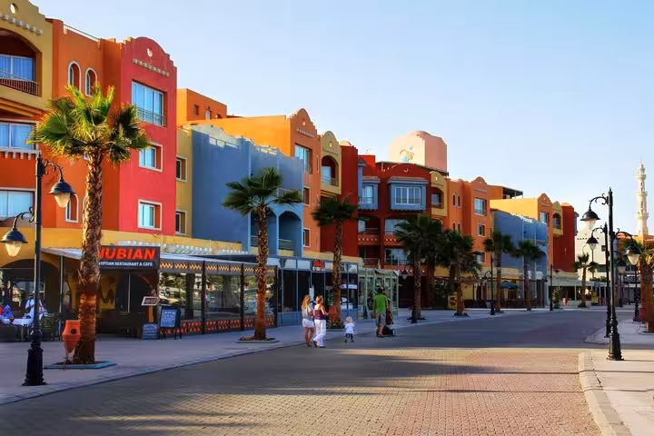 Colorful Hurghada downtown street with palm trees and shops, featured on a private city tour with shopping stop