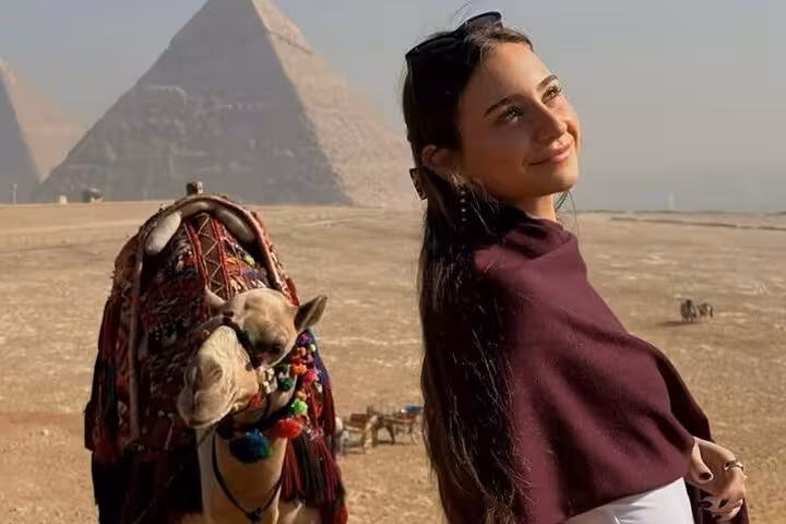 Traveler with camel at the Giza Pyramids on a Hurghada small group tour to Cairo, including the Grand Egyptian Museum