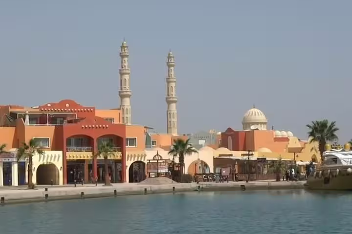 Hurghada Marina waterfront with mosque minarets and pastel buildings, scenic stop on a customized city tour