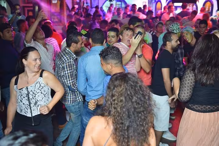 Tourists dancing in a lively Hurghada nightclub during a private night tour with guide and hotel pickup