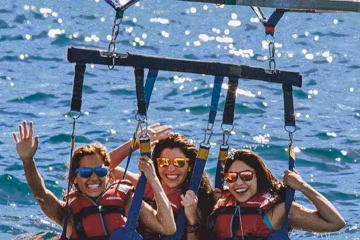 Friends smiling in harness on Hurghada parasailing tour, Red Sea adventure from Soma Bay and El Gouna