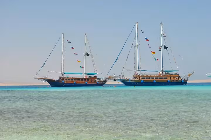 Two Hurghada pirate sailing boats anchored in turquoise Orange Bay, Red Sea cruise with buffet lunch