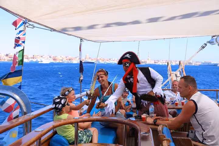 Pirate-themed crew entertains guests on Hurghada Pirates sailing boat cruise to Orange Bay with drinks