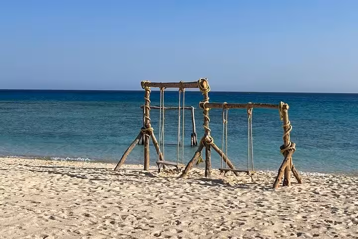 Rustic beach swing on Orange Bay, Hurghada, on Pirates sailing boat trip with buffet lunch and snorkeling