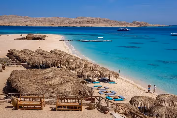 Sandy Hurghada beach with thatched huts on the Red Sea, relaxing stop on a Luxor to Hurghada snorkeling tour