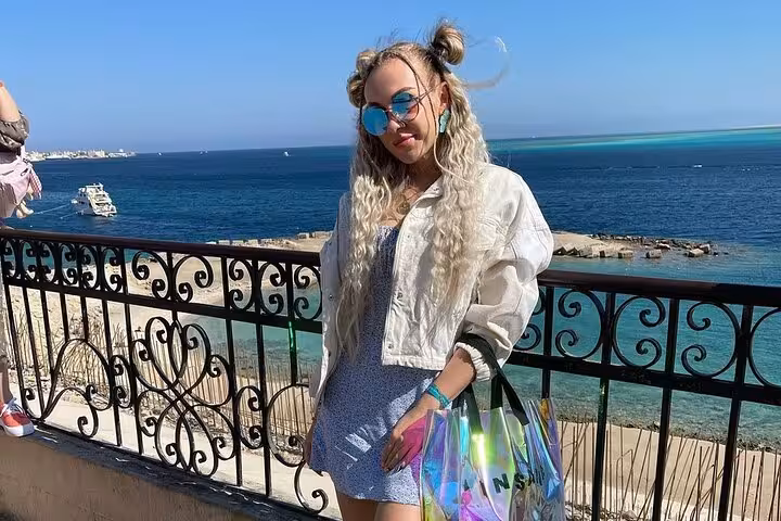 Traveler at Hurghada Red Sea viewpoint with iron railing and turquoise water, featured on a private city tour