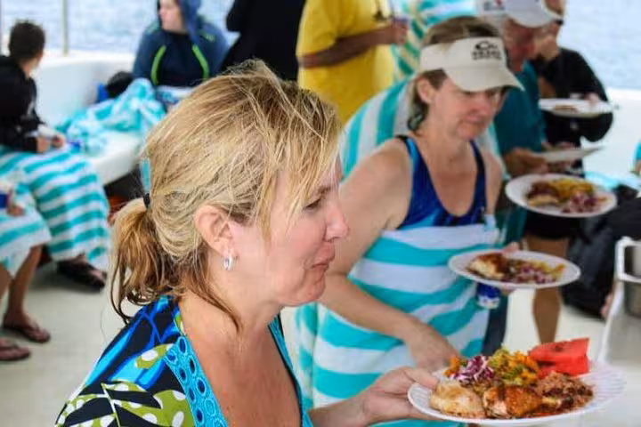 Guests enjoying lunch buffet on Hurghada snorkeling boat, Red Sea day trip from Luxor with onboard meal