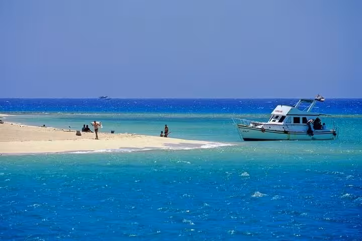 Boat anchored by sandy island in Hurghada Red Sea, part of Luxor to Hurghada snorkeling day tour