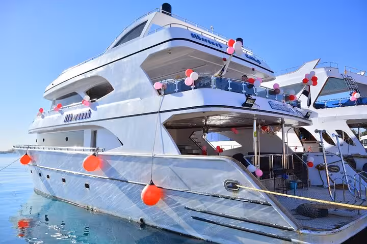 Balloon-decorated Hurghada yacht at marina for VIP swim with dolphins, snorkeling cruise and Red Sea water sports