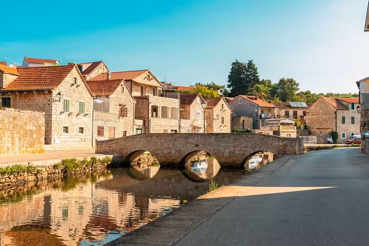 Stone bridge and traditional village on Hvar Island north shore, Croatia, scenic stop on a private boat tour