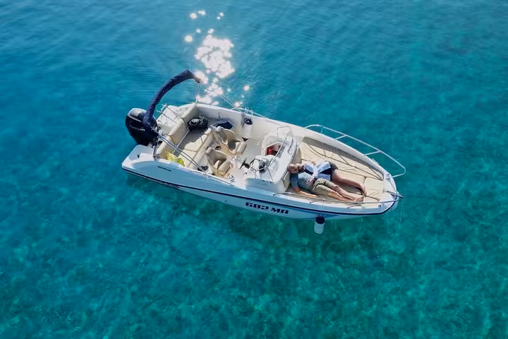 Private speedboat anchored in crystal-clear Adriatic near Hvar North Shore, relaxing on boat tour