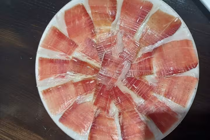 Plate of finely sliced Iberian ham at Marbella market, highlighting culinary delights on the Taste of Marbella tour.