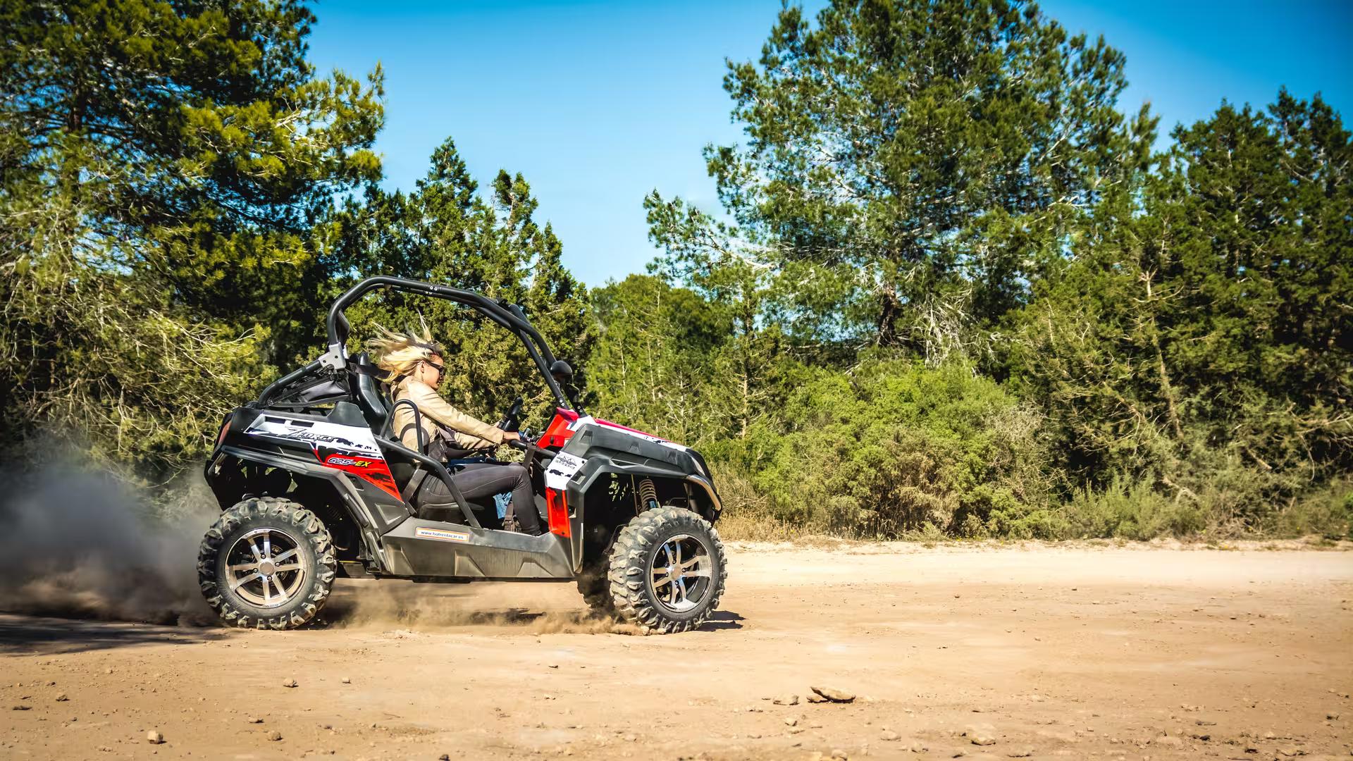 Off-road buggy tour in southern Ibiza kicking up dust on dirt road, Salinas nature day trip adventure