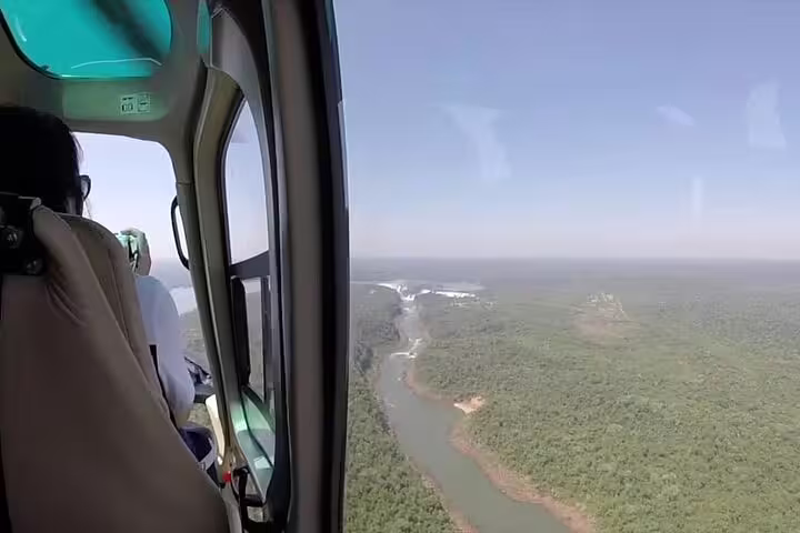 Aerial view from a helicopter over the lush forests and scenic Iguazu Falls during a panoramic flight.