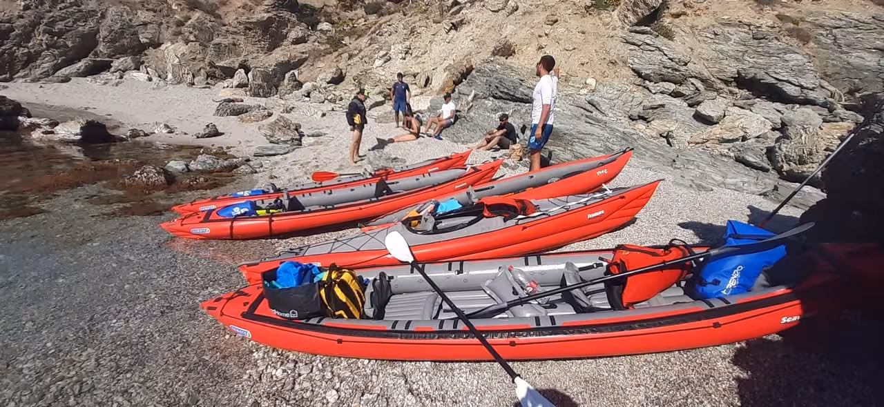 Inflatable sea kayaks lined on a rocky beach, gear ready for guided kayak trip to Îles des Embiez and Cap Sicié