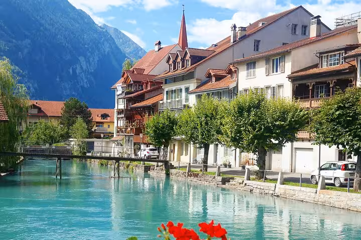 Scenic canal lined with charming houses in Interlaken, showcasing serene beauty on the private Milan transfer route.