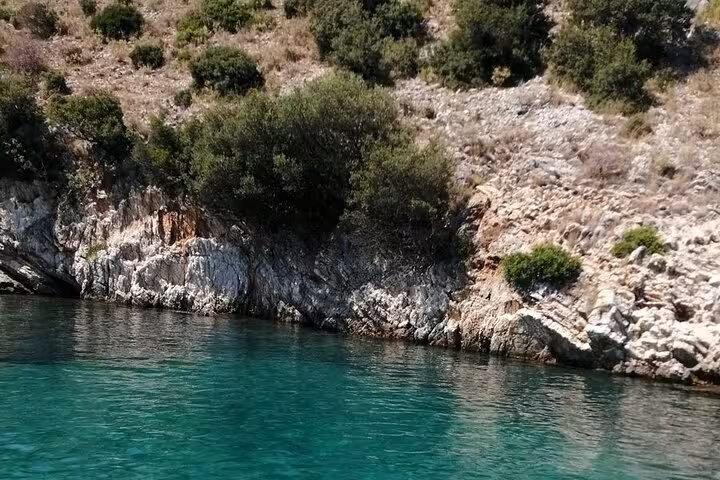 Rocky Ionian coastline and crystal-clear emerald water on a locals BBQ boat trip, perfect for swimming stop