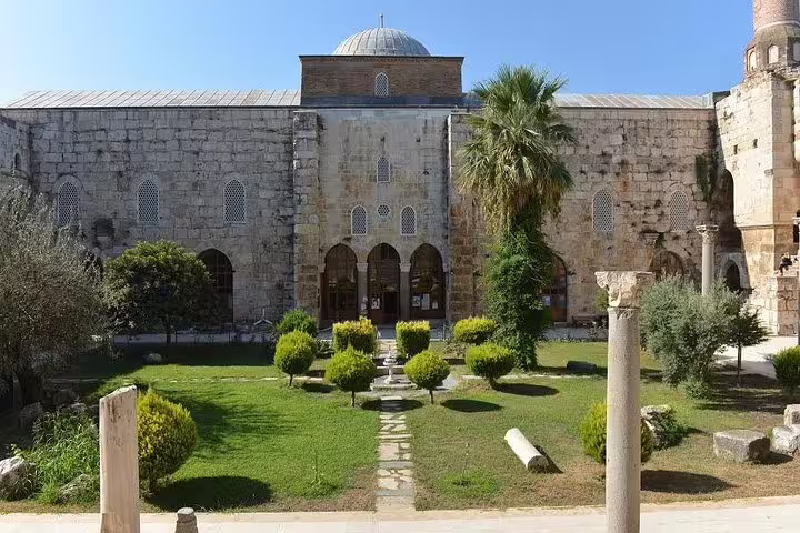 Front view of Isa Bey Mosque's stone architecture and courtyard on the Ephesus private tour from Kusadasi Port.