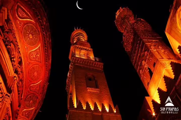 Illuminated minarets and crescent moon at Islamic Cairo on a day tour from Alexandria, evening city sights