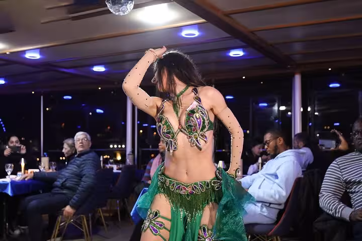 Turkish night show belly dancer performing on Istanbul Bosphorus dinner cruise with guests seated at tables