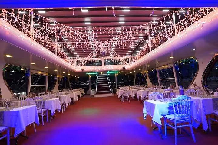 Elegant dining deck set for Istanbul Bosphorus dinner cruise Turkish night with private table and city views