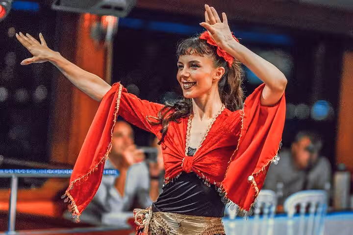 Turkish night dancer in red costume performing on Istanbul Bosphorus dinner cruise with live show