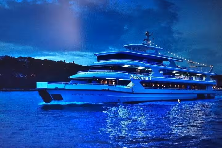 Illuminated Istanbul Bosphorus dinner cruise yacht sailing at dusk, Turkish night show and private table