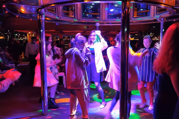 Guests dancing under colorful lights on Istanbul Bosphorus dinner cruise party with live Turkish night show