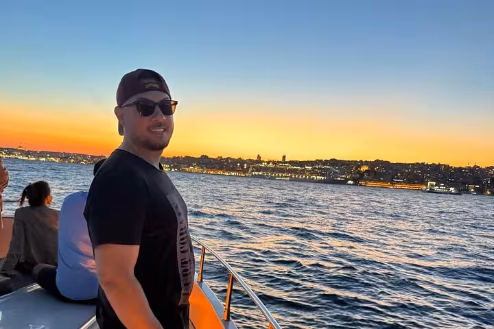 Traveler on the deck of a luxury yacht enjoying an Istanbul Bosphorus sunset cruise with golden skyline views