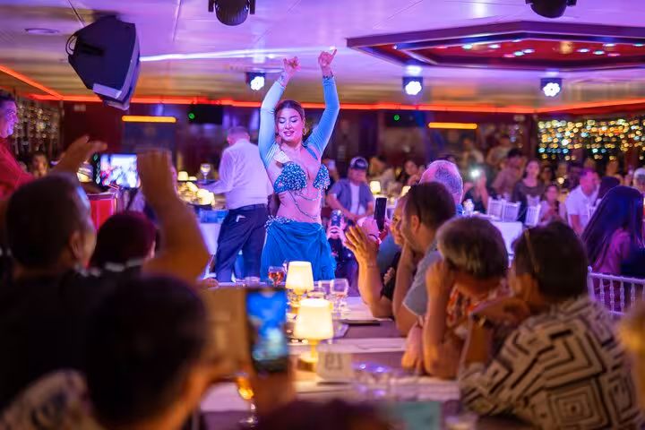 Belly dancer performing at Istanbul Bosphorus New Year’s Eve dinner cruise party with festive crowd