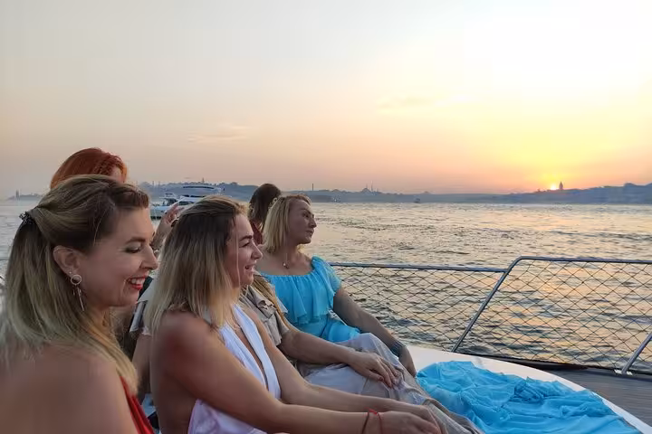 Friends relaxing on luxury yacht at sunset on Bosphorus Strait, Istanbul evening cruise with sea views