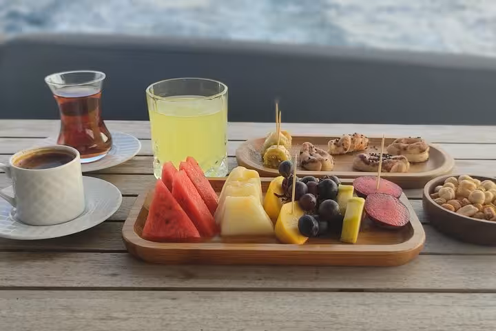Turkish tea and fresh fruit platter served on a luxury yacht during Istanbul Bosphorus sunset cruise