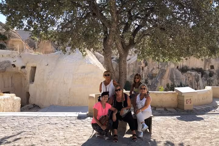 Grupo de viajeras en Cappadocia bajo un árbol, paisaje de cuevas, tour Estambul Cappadocia en español