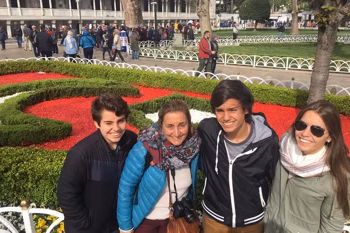 Group photo at Sultanahmet Square flower beds on 6-day Istanbul Cappadocia tour in Spanish with flights