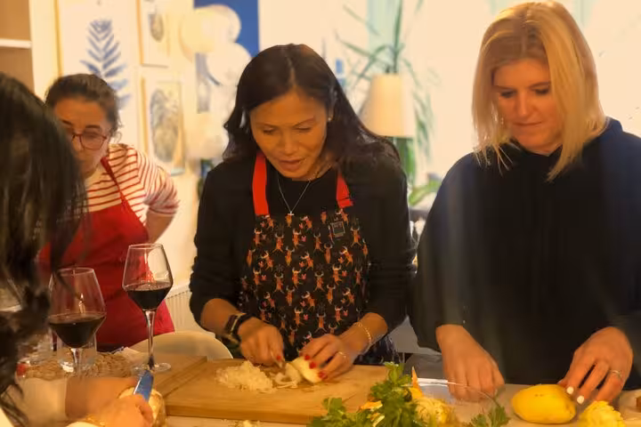 Guests chop herbs and onions during traditional home cooking class with a local in Istanbul city center