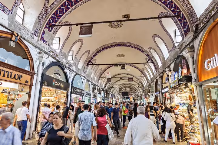 Crowded arched corridor inside Istanbul Grand Bazaar with shops and travelers on an all-inclusive guided tour