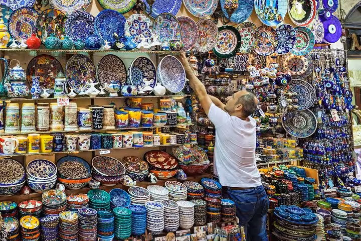 Man browsing colorful Turkish ceramics and evil eye souvenirs at Istanbul Grand Bazaar on private guided tour