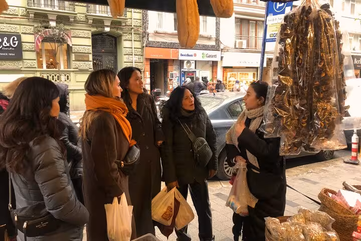 Guests browse Istanbul city center market spices and dried goods on a traditional home cooking tour