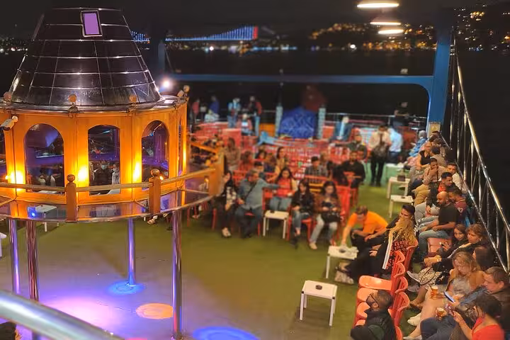 Open-air deck seating on Istanbul New Year’s Eve party cruise with Bosphorus Bridge lights at night
