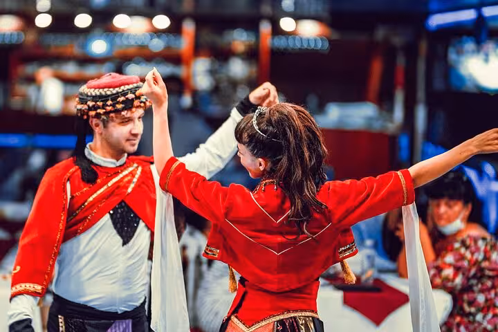 Turkish folk dance show in red costumes on Istanbul New Year’s Eve party cruise with dinner entertainment
