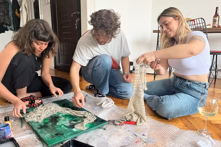Guests create textured abstract art while sipping wine during Istanbul paint and wine at a local home