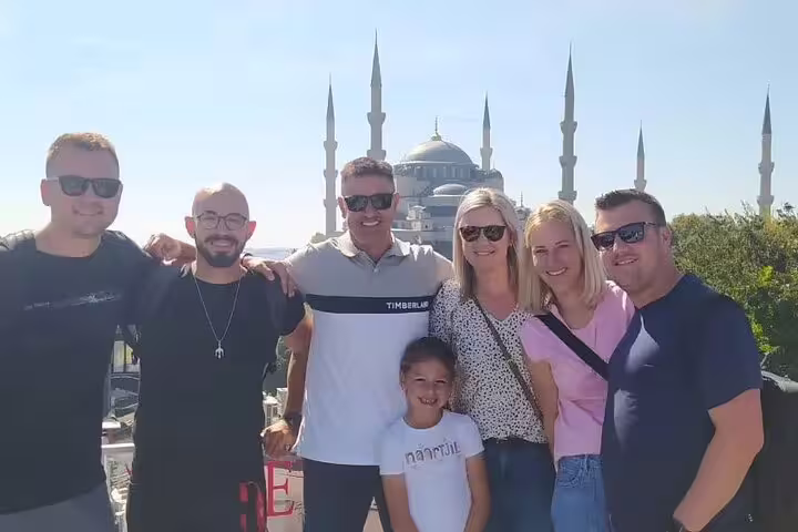 Happy group of tourists with the Blue Mosque in the background on an Istanbul guided private tour.