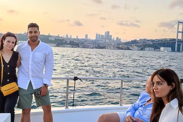 Couple on Bosphorus luxury yacht at sunset with Istanbul skyline and Bosphorus Bridge in the background