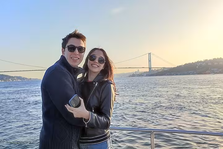 Couple on a luxury Bosphorus sunset cruise with Istanbul bridge views from a private yacht deck